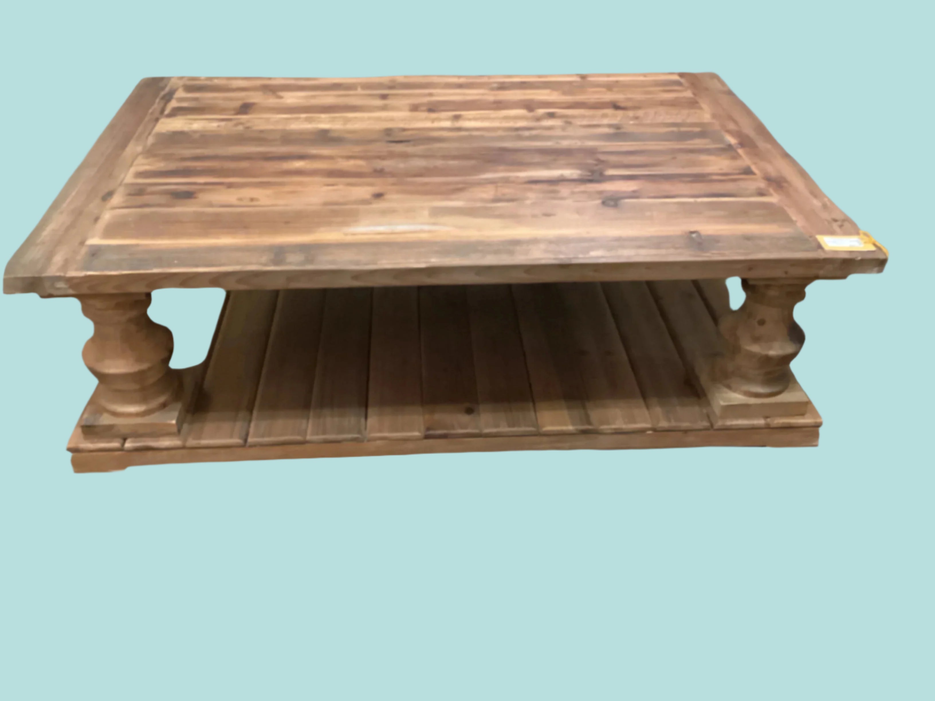 Wooden coffee table with a rustic design on a carpeted floor.