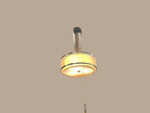 A gold and silver chandelier hanging from the ceiling, with a visible central light fixture surrounded by a ring, in an indoor setting with various decorative items on the walls.
