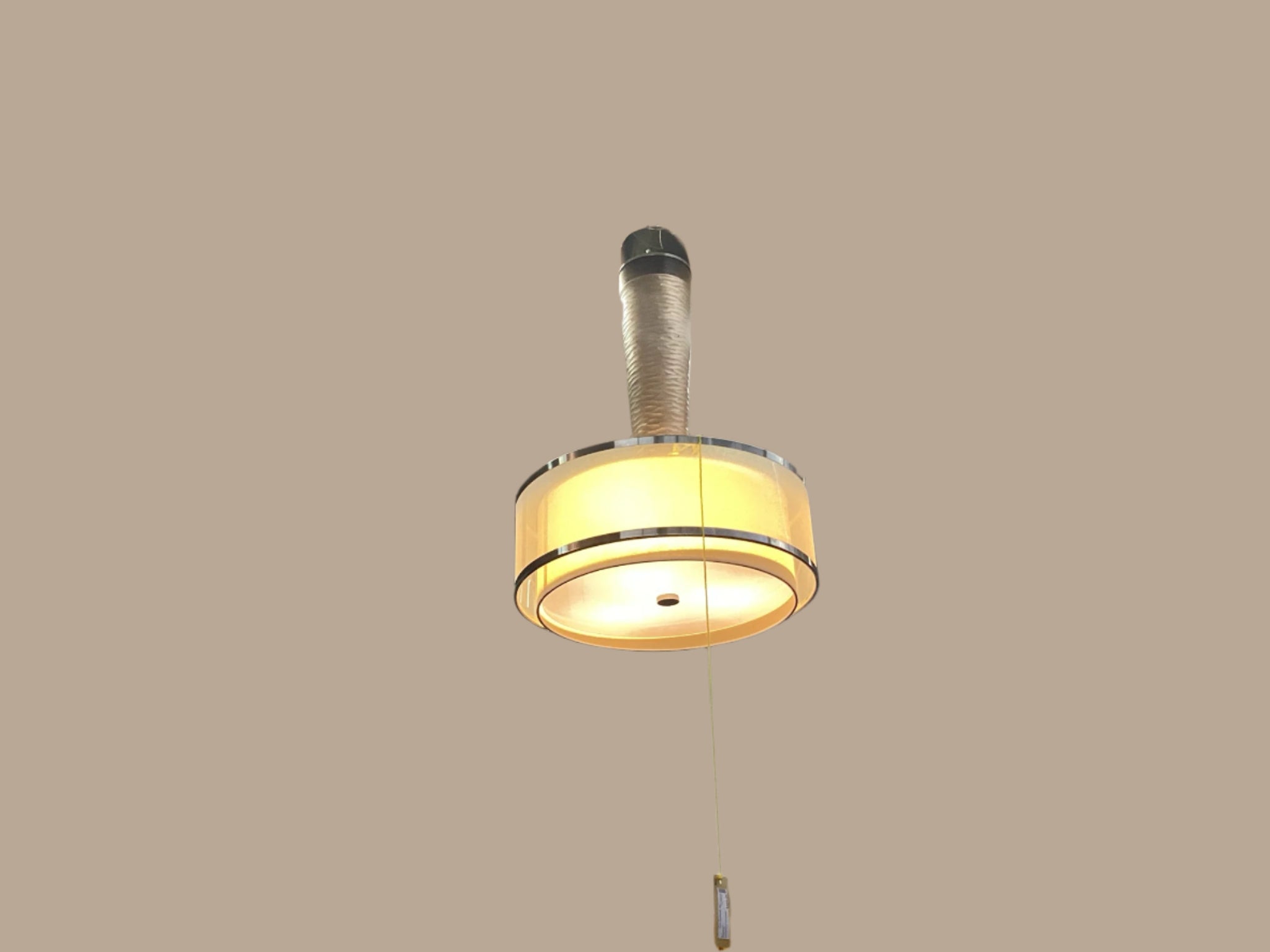 A gold and silver chandelier hanging from the ceiling, with a visible central light fixture surrounded by a ring, in an indoor setting with various decorative items on the walls.