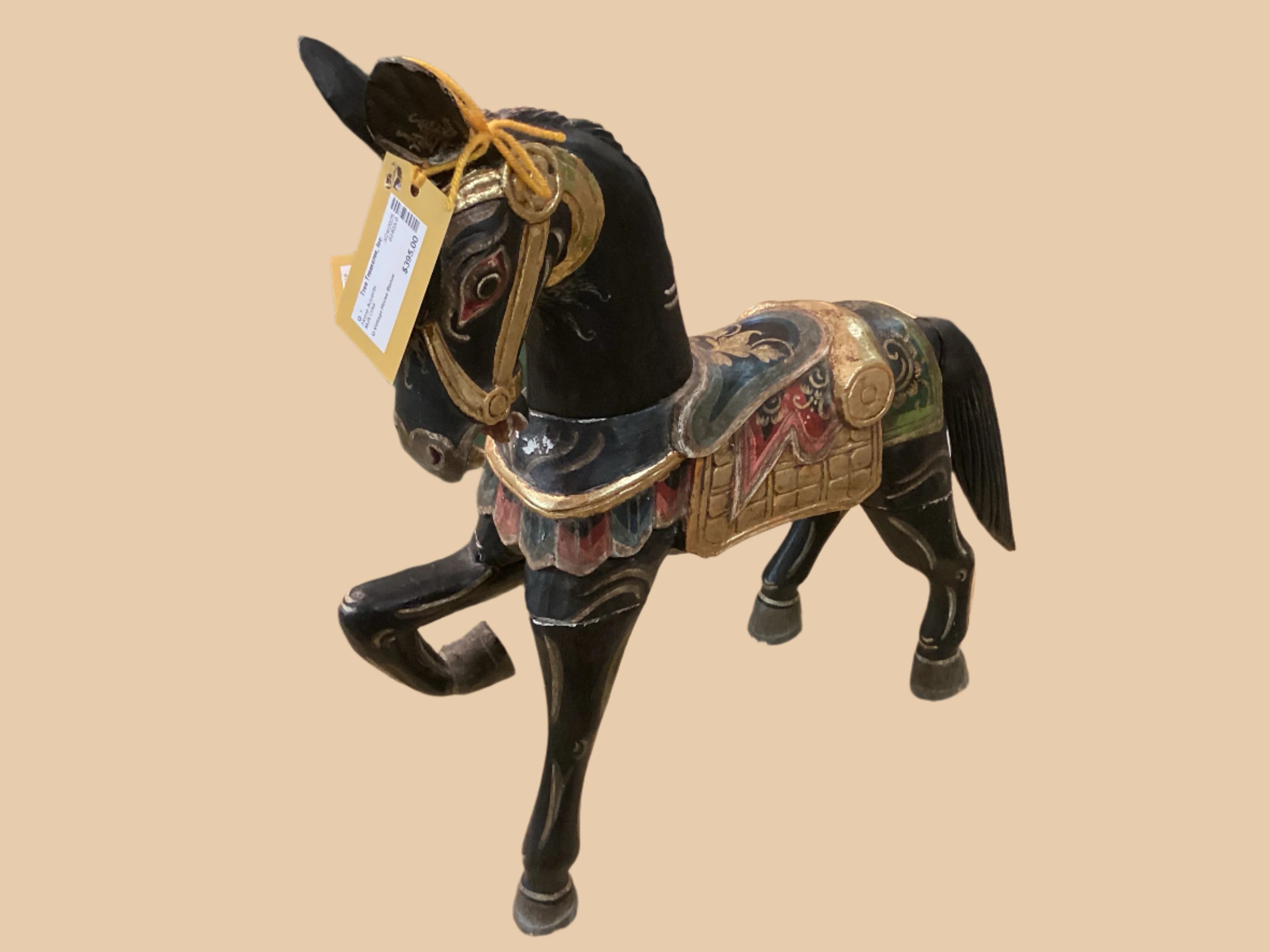 A multicolored vintage horse statue with decorative details, displayed on a table.