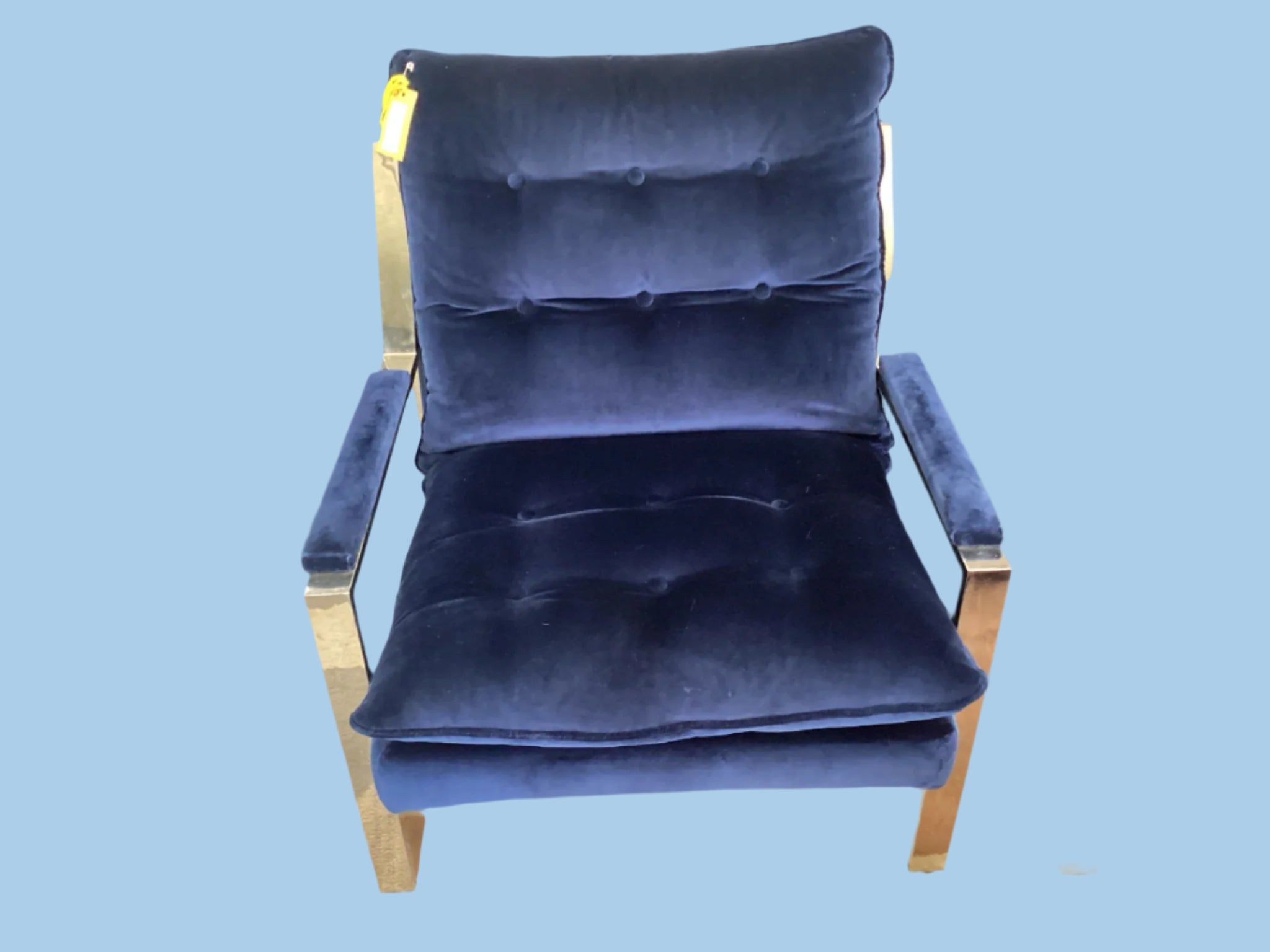 Blue velvet chair in a showroom setting with other furniture.