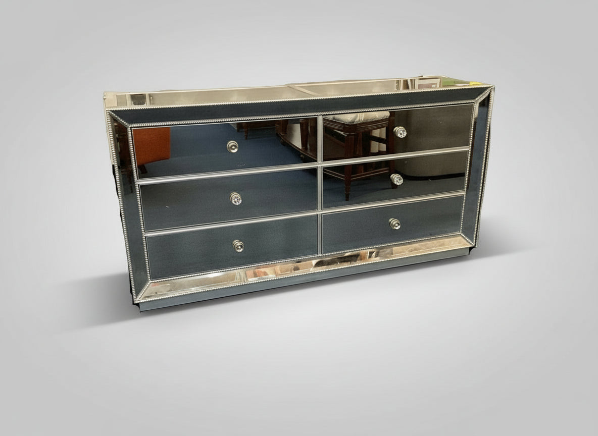 Mirrored dresser with silver trim on a gray background