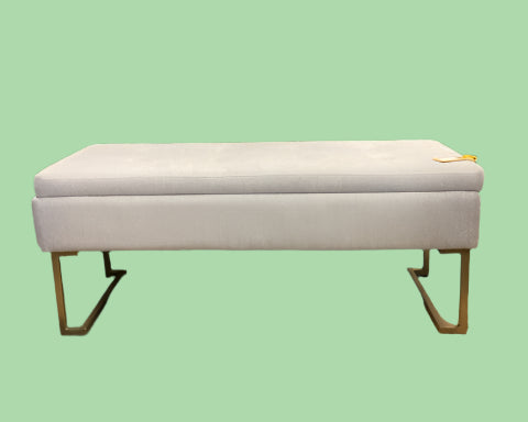 White storage bench with gold legs on a light green background